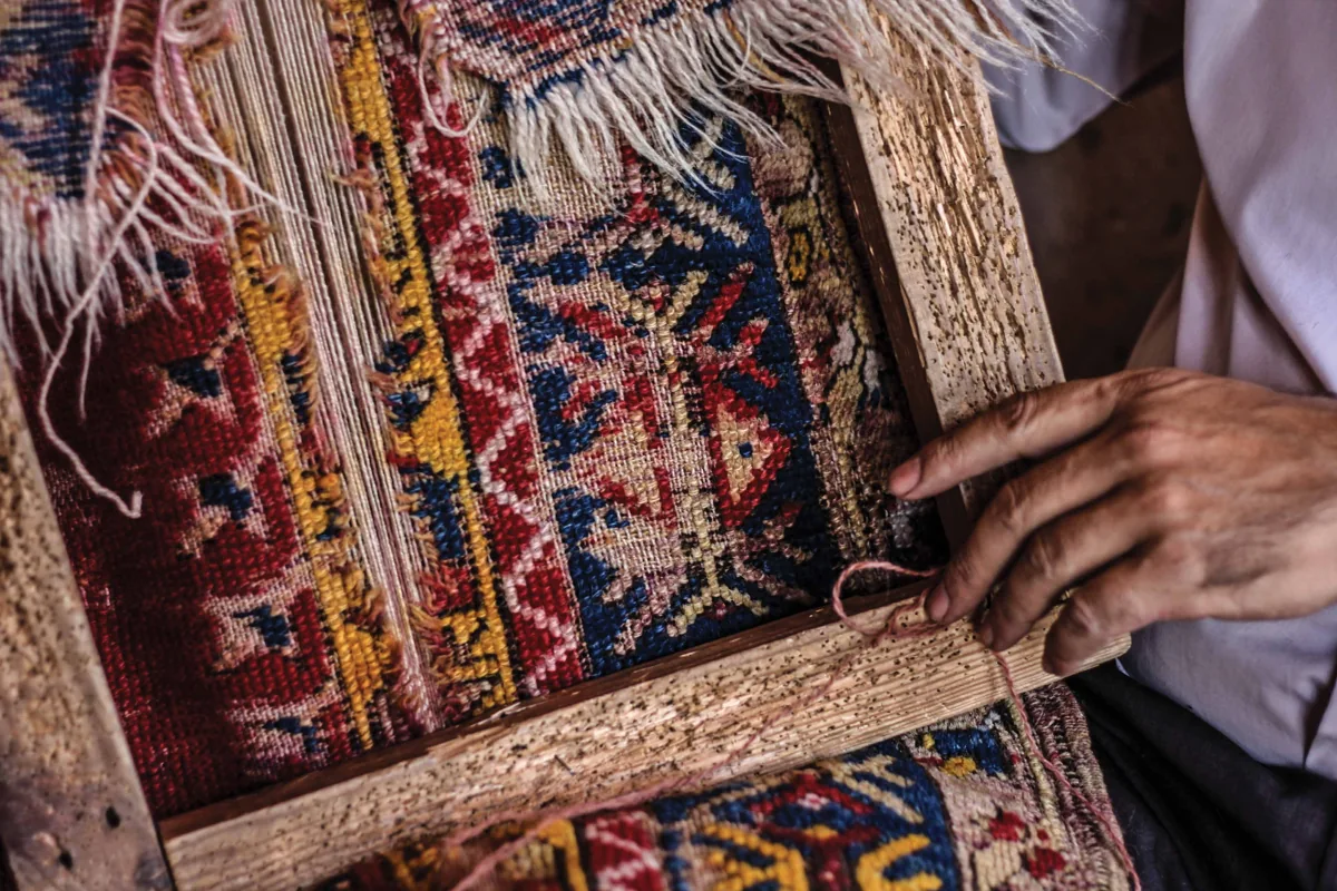 Hands at work on a patterned carpet