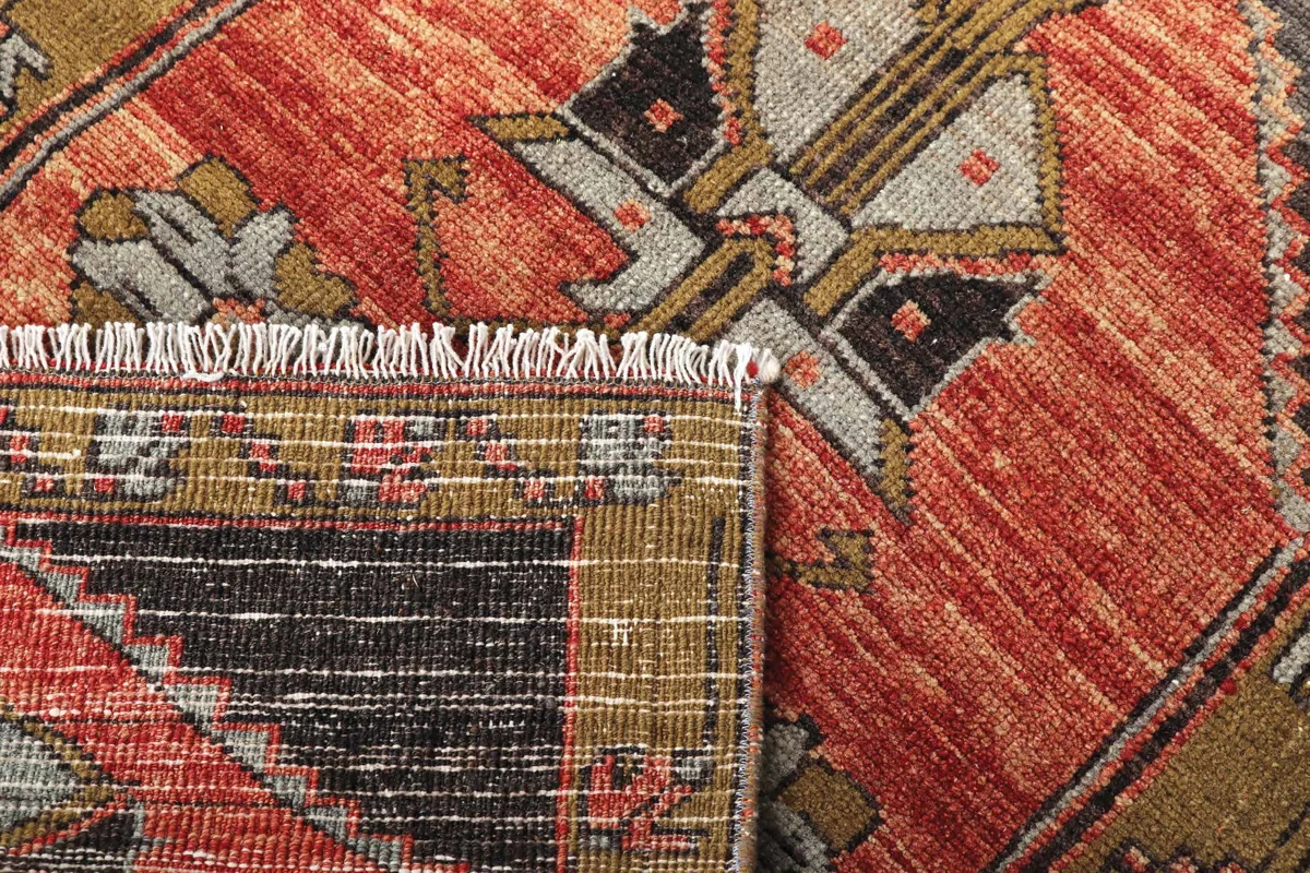 Layers of red, ochre and charcoal patterned carpet
